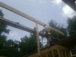 Carpenter setting a ridge beam over a new addition frame — Ice Dam Removal by Roofing Brothers in Ann Arbor