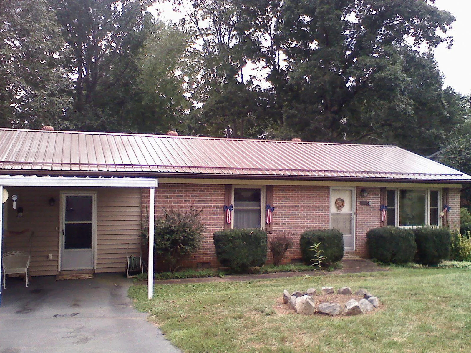 Bronze metal roof and carport on a brick ranch home — Roof Repair work by our crew in Ann Arbor